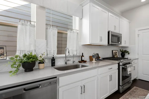 a kitchen with stainless steel appliances white cabinets and a sink