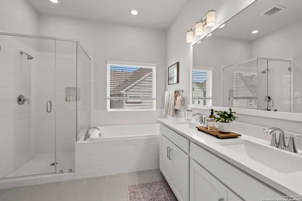 a bathroom with a sink a large mirror and shower