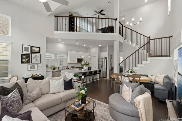 a living room with furniture kitchen view and a wooden floor