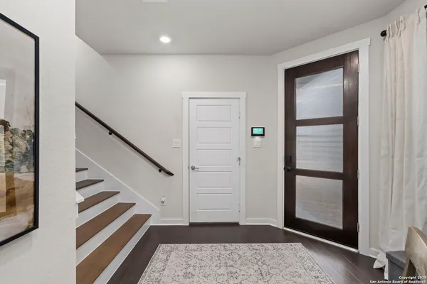 a view of a hallway with entryway and stairs