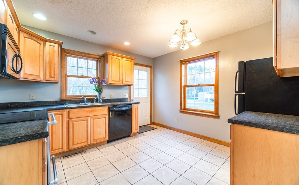 592 Russell Road Westfield, MA 01085 - Photo 4 of 32 a kitchen with stainless steel appliances granite countertop a refrigerator a sink dishwasher a stove and white countertops with wooden floor
