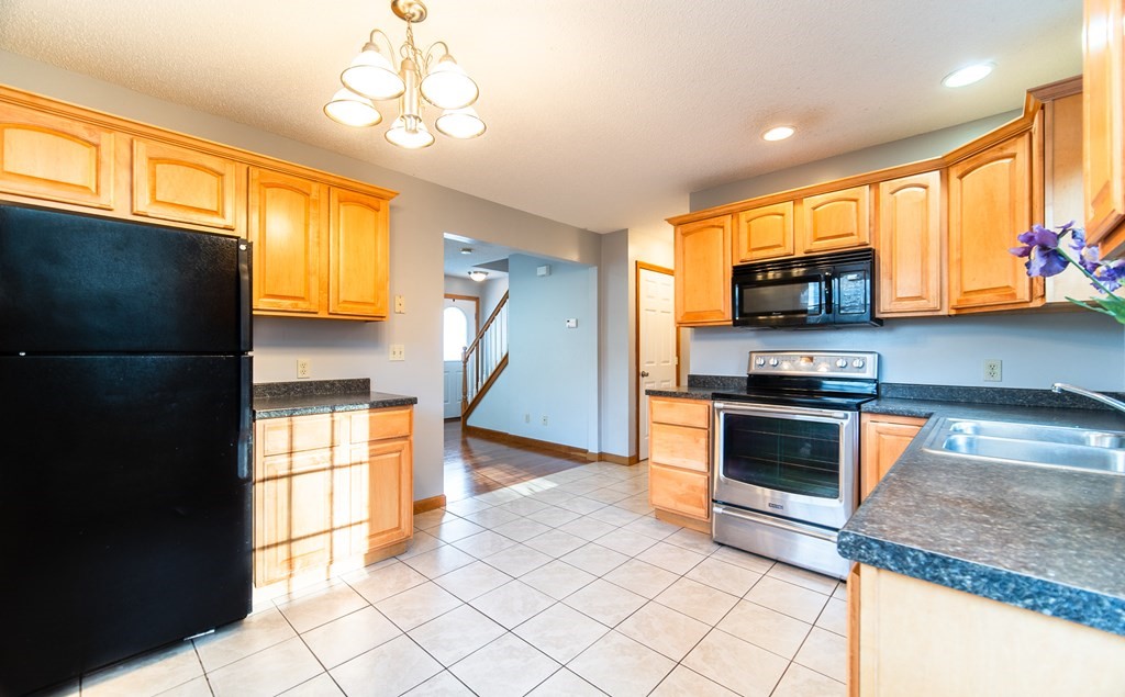 592 Russell Road Westfield, MA 01085 - Photo 7 of 32 a kitchen with stainless steel appliances a stove a sink and a microwave