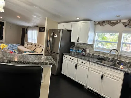 a bathroom with a granite countertop sink mirror and shower