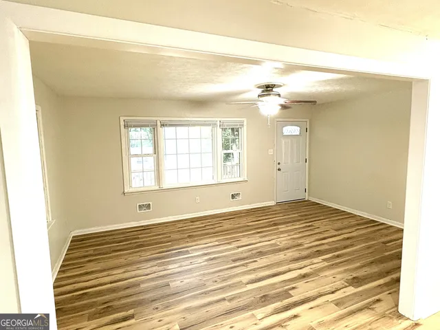 a living room with stainless steel appliances kitchen island granite countertop a refrigerator and a sink