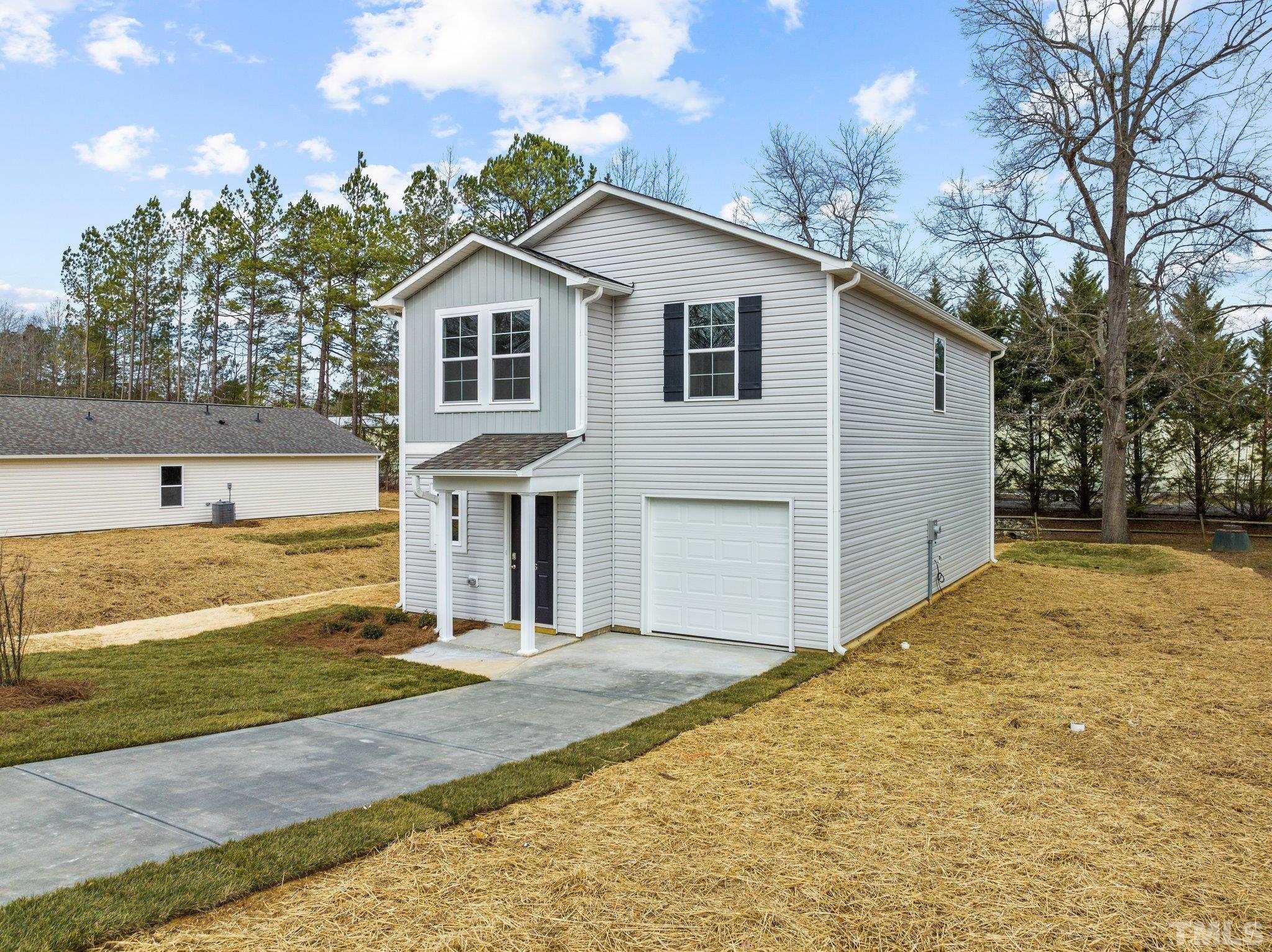 96 Somerset Drive Roxboro, NC 27573 - Photo 2 of 29 a view of a white house with a yard and large tree