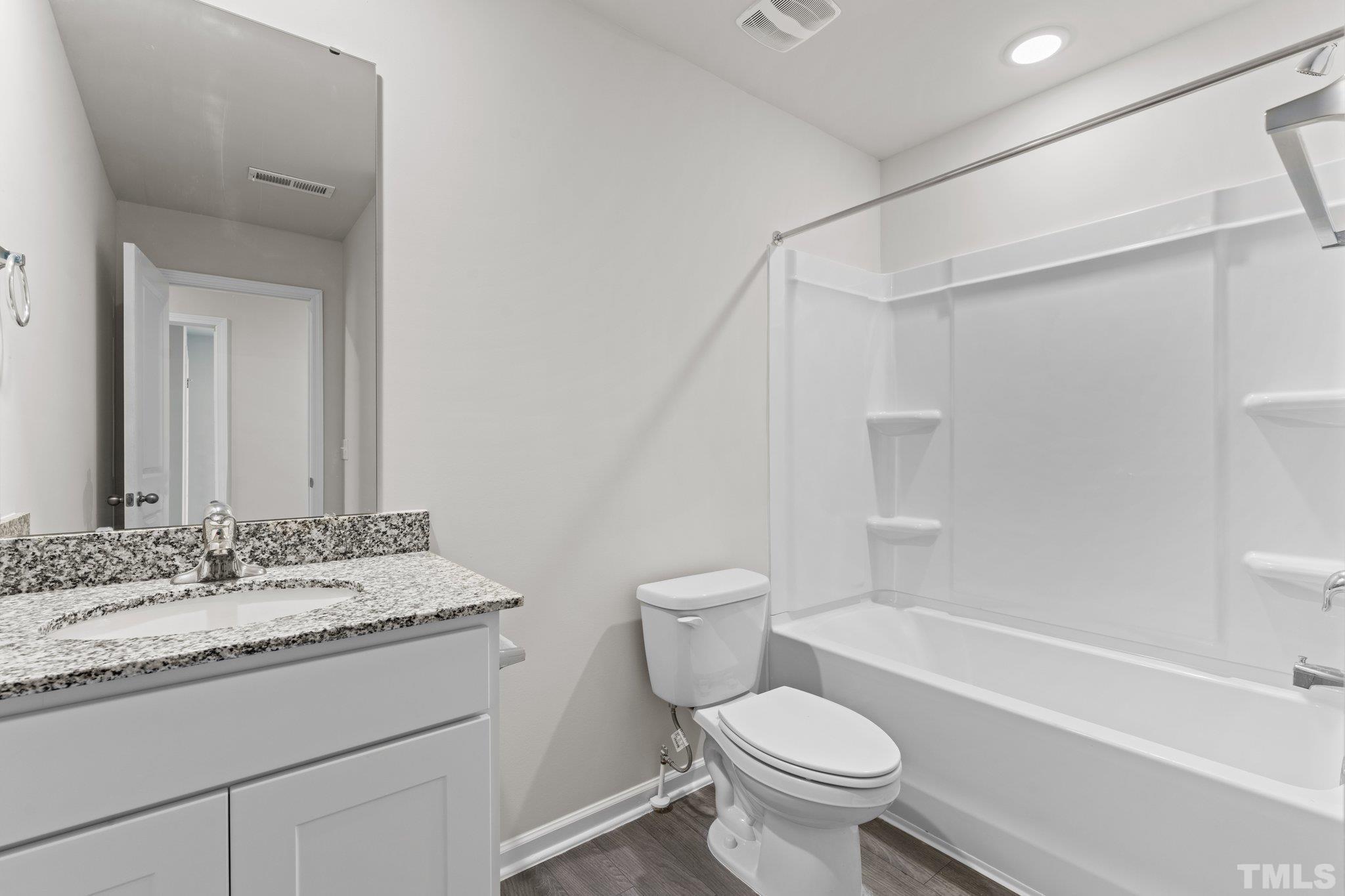 96 Somerset Drive Roxboro, NC 27573 - Photo 26 of 29 a bathroom with a sink toilet vanity and shower