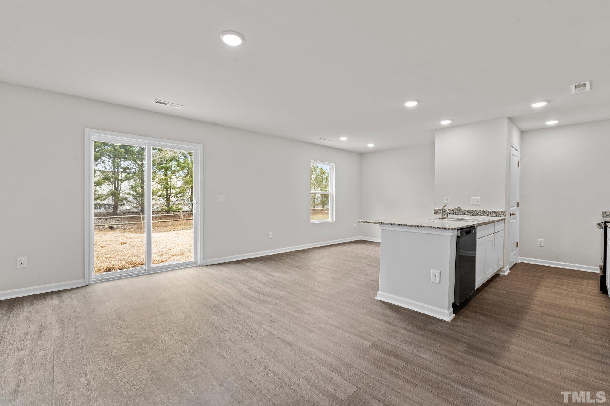 96 Somerset Drive Roxboro, NC 27573 - Photo 10 of 29 a view of an empty room with window and wooden floor