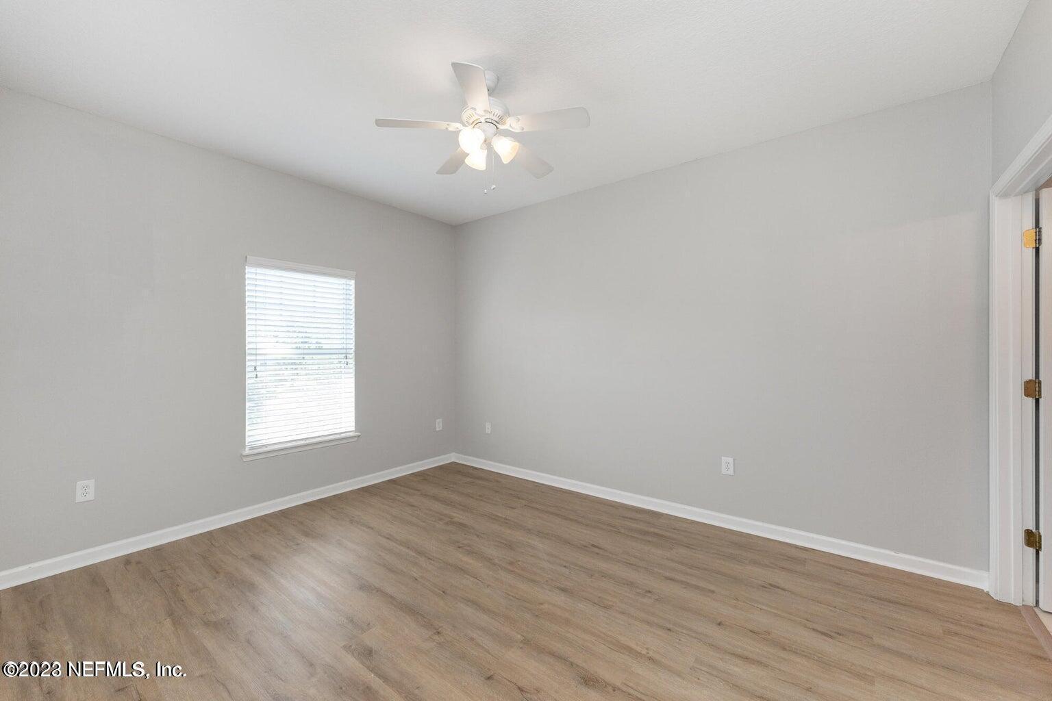 8226 Green Parrot Road, Unit 308 Jacksonville, FL 32256 - Photo 16 of 31 a view of an empty room with wooden floor and a window