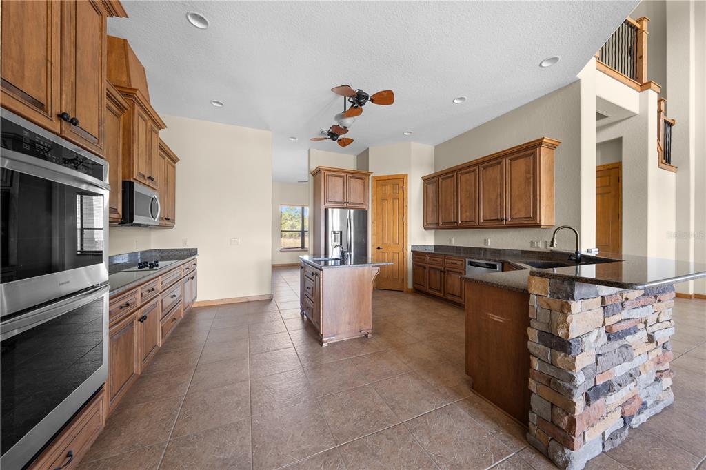 3911 Story Road St. Cloud, FL 34772 - Photo 14 of 97 a kitchen with stainless steel appliances granite countertop a stove a sink dishwasher and a refrigerator