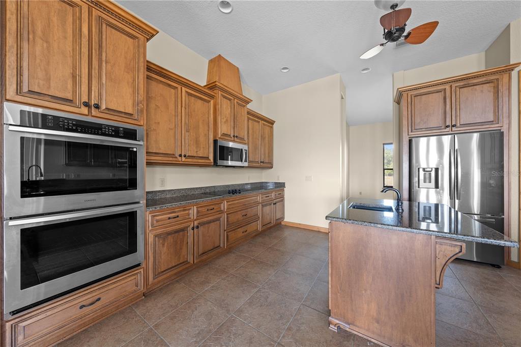 3911 Story Road St. Cloud, FL 34772 - Photo 17 of 97 a kitchen with stainless steel appliances granite countertop a stove microwave and cabinets