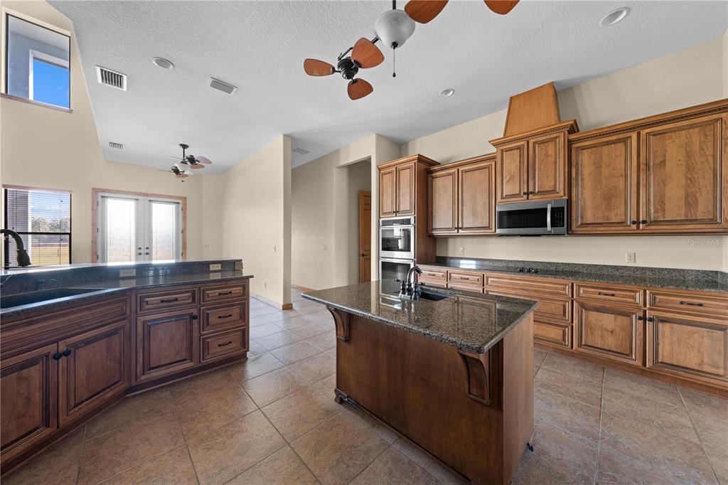 3911 Story Road St. Cloud, FL 34772 - Photo 21 of 97 a kitchen with kitchen island granite countertop a sink counter top space appliances and cabinets