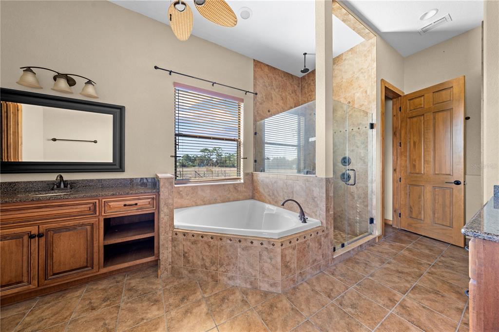 3911 Story Road St. Cloud, FL 34772 - Photo 26 of 97 a spacious bathroom with a tub a double vanity sink a window and a mirror