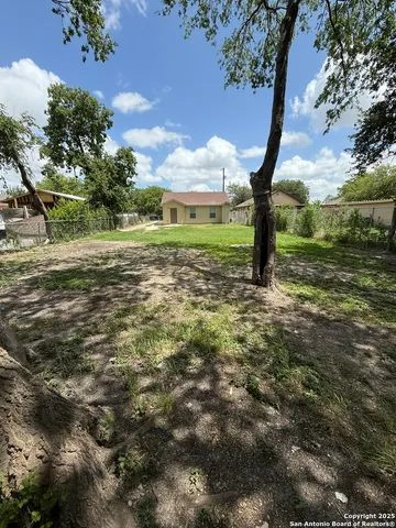 a view of a field with large trees