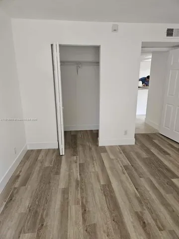 an empty room with wooden floor and closet