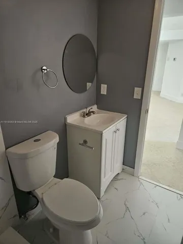 a bathroom with a toilet sink and mirror