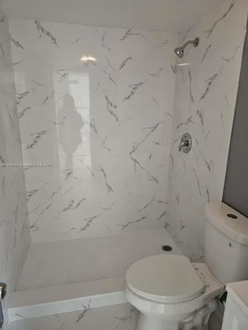 a bathroom with a toilet and a shower