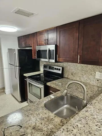 a kitchen with a sink cabinets and stainless steel appliances