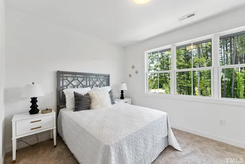 a bedroom with a bed and a large window