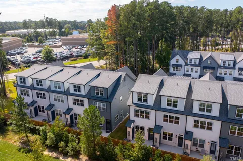 a aerial view of a residential apartment building with a yard and sitting area