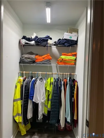 a view of walk in closet with clothes and shoes