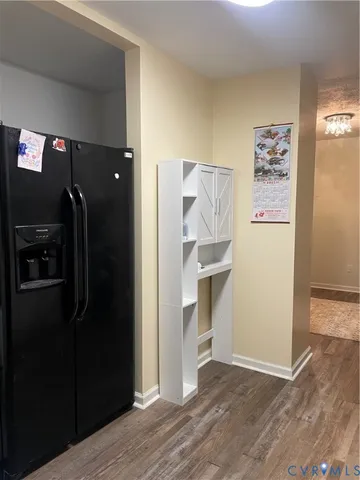 a view of a refrigerator in kitchen and an empty room