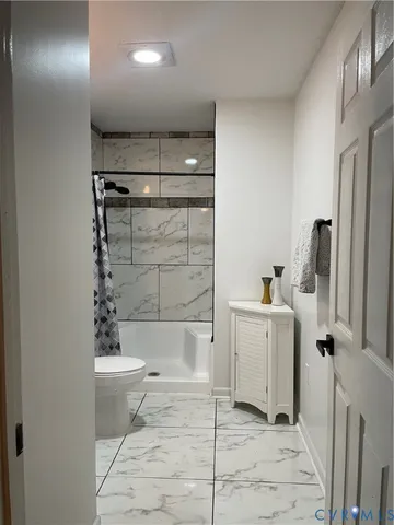 a bathroom with a bathtub a toilet and a shower