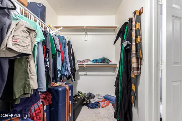 a view of walk in closet with clothes and shoes
