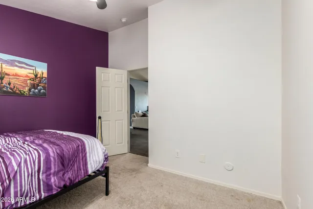 a bedroom with a bed and painting on the wall