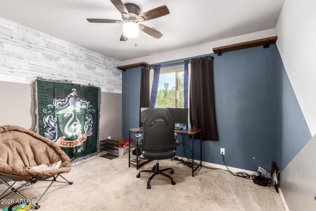 a view of a workspace with furniture and a window