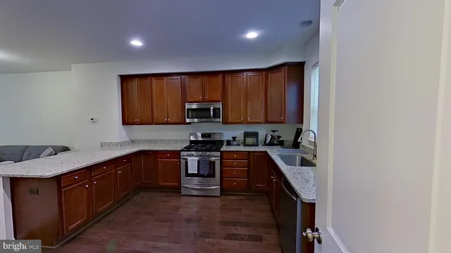 a kitchen with stainless steel appliances granite countertop a stove top oven a sink and dishwasher