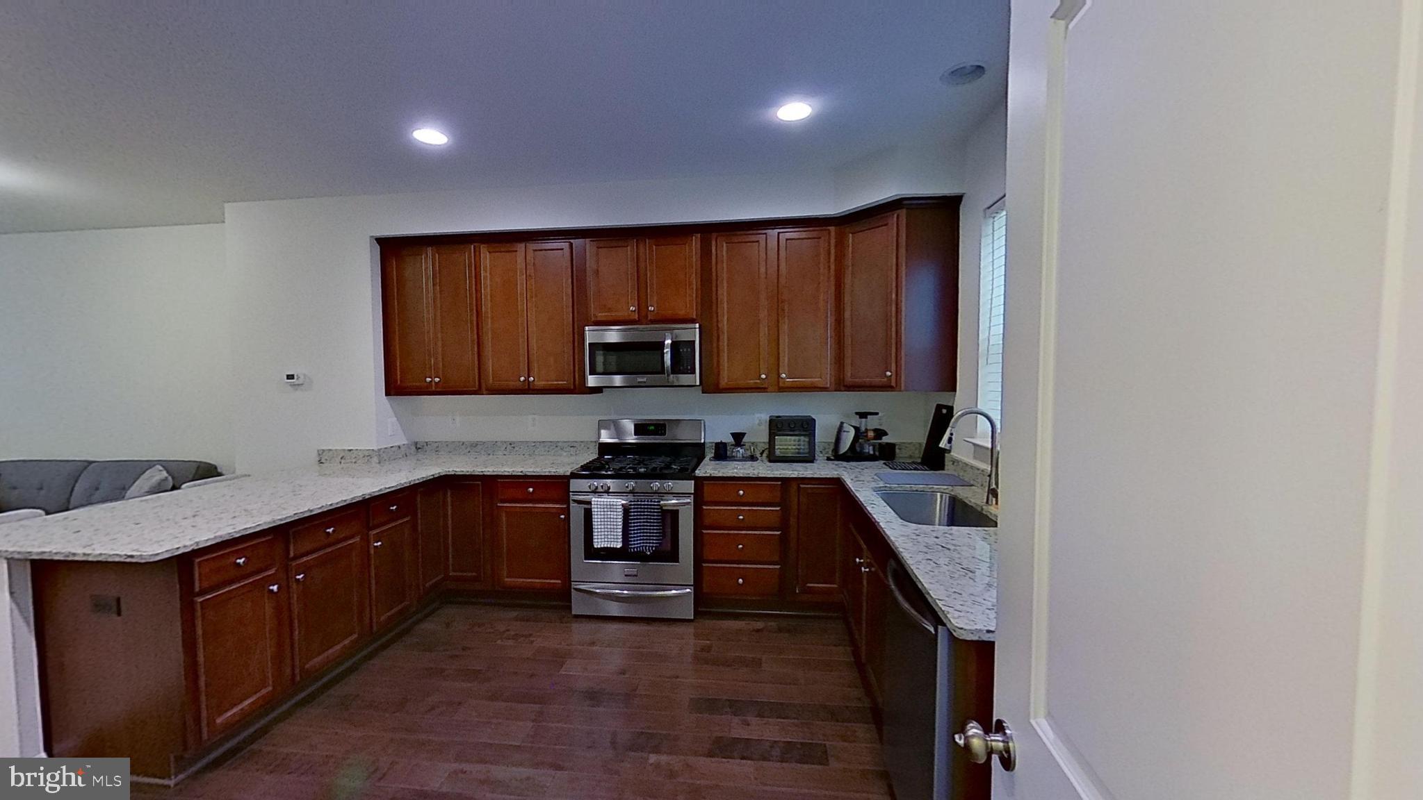 23340 Starry Way California, MD 20619 - Photo 11 of 18 a kitchen with stainless steel appliances granite countertop a stove top oven a sink and dishwasher
