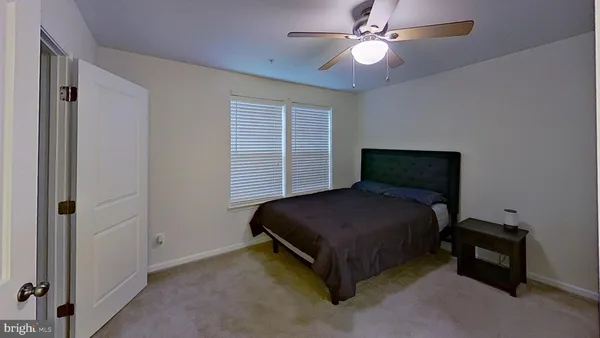 a bedroom with a bed and a ceiling fan