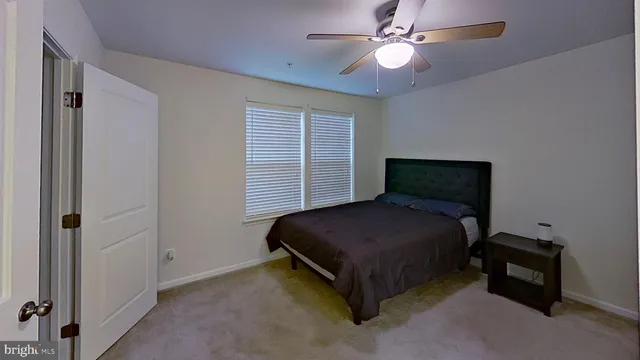 a bedroom with a bed and a ceiling fan