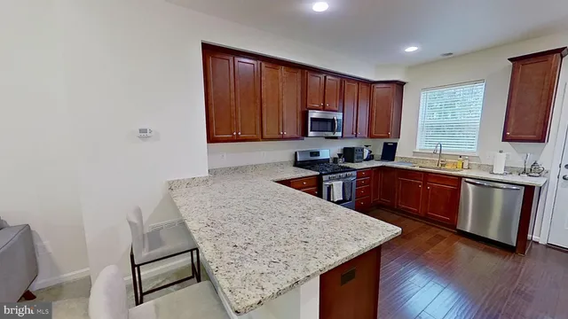 a kitchen with a sink a stove a microwave a center island and a window