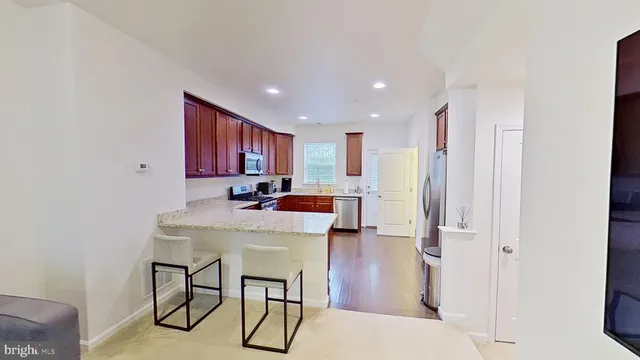 a kitchen with stainless steel appliances a table and chairs
