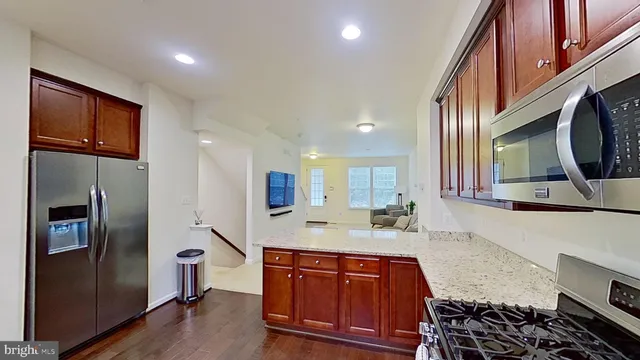 a kitchen with stainless steel appliances granite countertop a refrigerator and a stove top oven