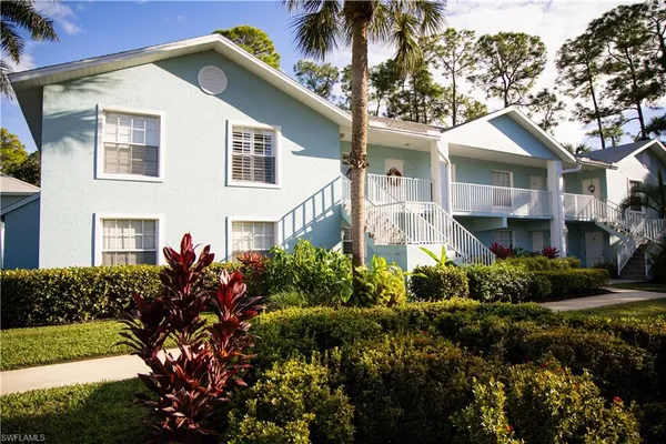 a front view of a house with a yard and potted plants