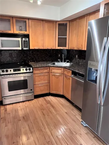 a kitchen with stainless steel appliances granite countertop a stove a sink and a refrigerator