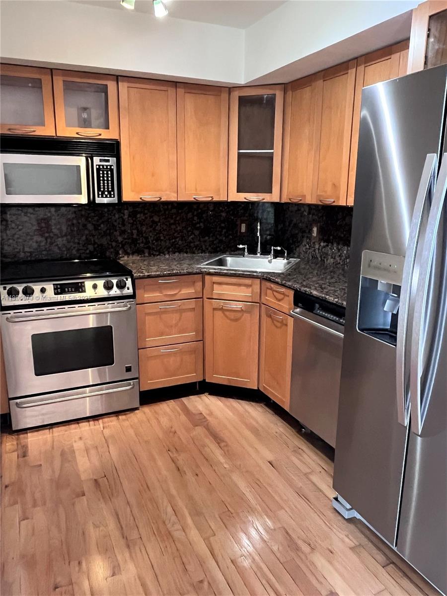 200 Southeast 15th Road, Unit 6A Miami, FL 33129 - Photo 3 of 14 a kitchen with stainless steel appliances granite countertop a stove a sink and a refrigerator