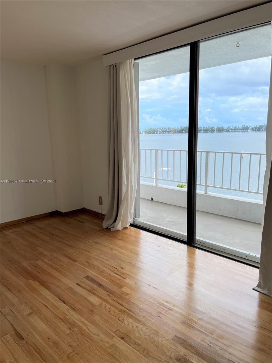 200 Southeast 15th Road, Unit 6A Miami, FL 33129 - Photo 5 of 14 a view of an empty room with wooden floor and a window