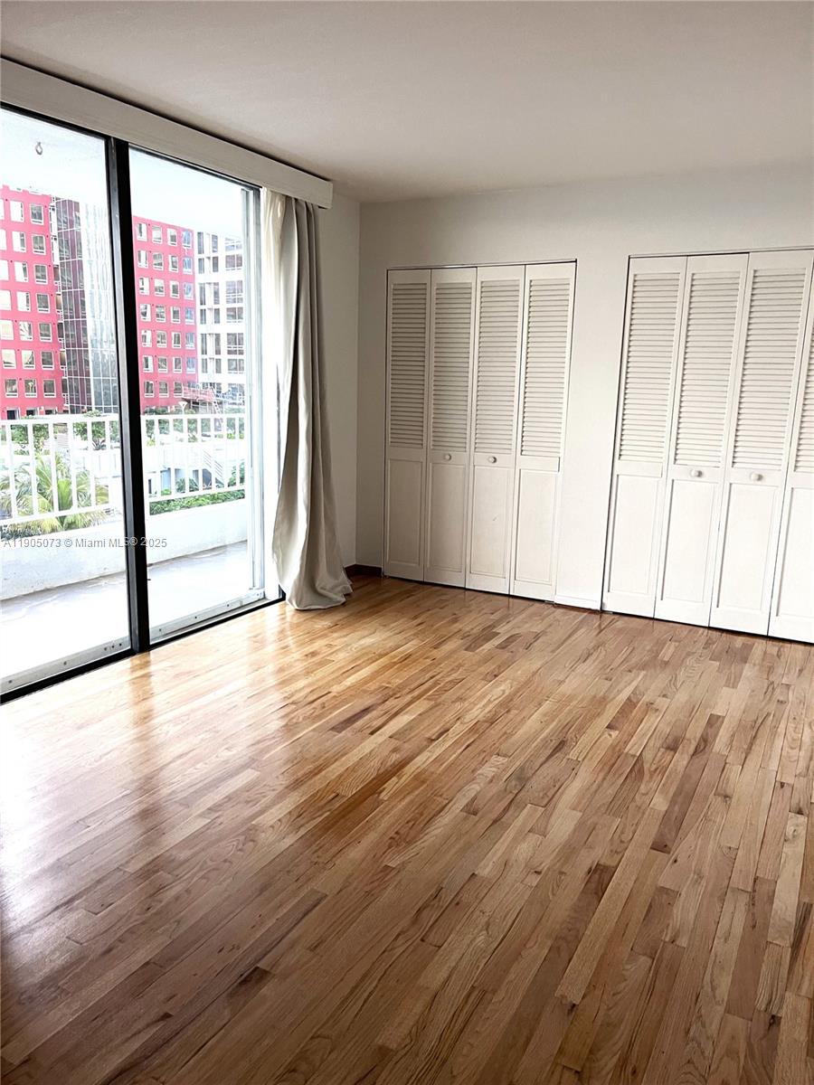 200 Southeast 15th Road, Unit 6A Miami, FL 33129 - Photo 6 of 14 a view of an empty room with wooden floor and a window