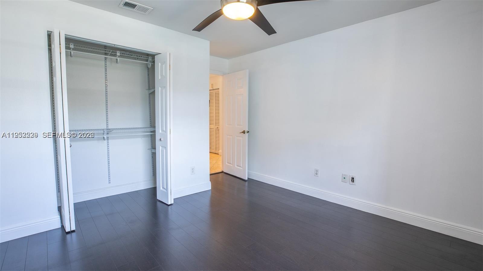14206 Southwest 97th Terrace Miami, FL 33186 - Photo 18 of 33 an empty room with wooden floor closet and windows