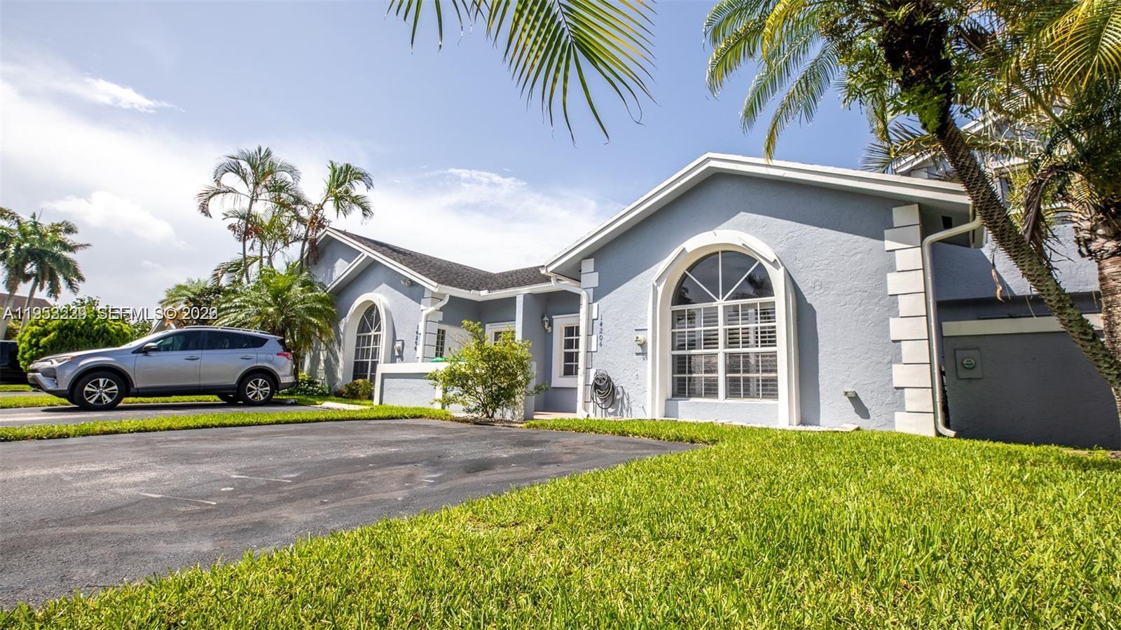 14206 Southwest 97th Terrace Miami, FL 33186 - Photo 2 of 33 a front view of a house with a garden and trees