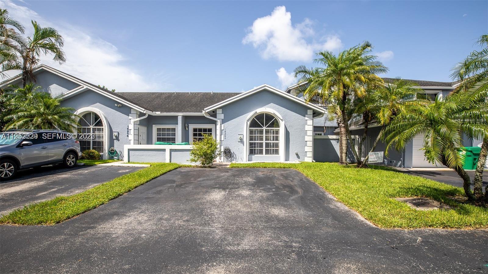 14206 Southwest 97th Terrace Miami, FL 33186 - Photo 3 of 33 a front view of a house with a yard and garage