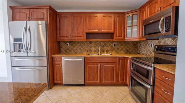 a kitchen with stainless steel appliances granite countertop a refrigerator microwave and sink
