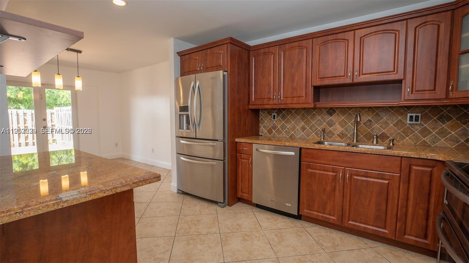 14206 Southwest 97th Terrace Miami, FL 33186 - Photo 10 of 33 a kitchen with stainless steel appliances granite countertop a refrigerator sink and cabinets