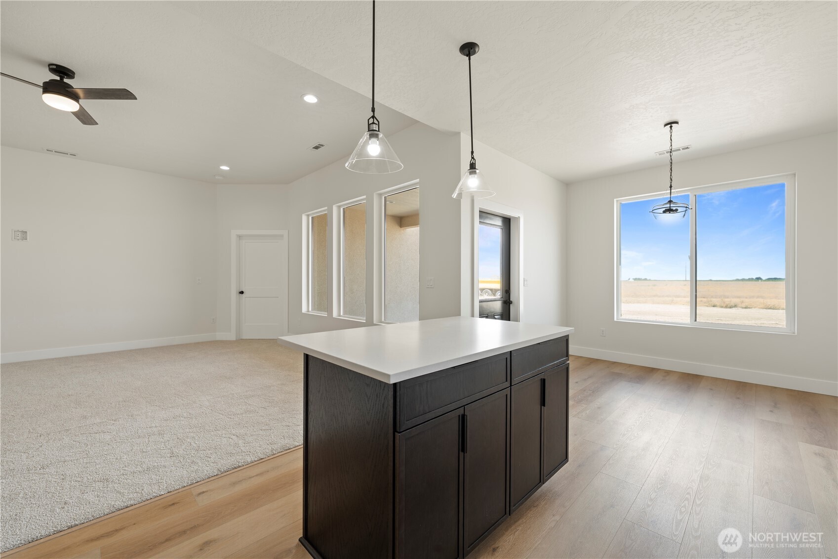1111 E Mount Othello, WA 99344 - Photo 11 of 34 a kitchen with a sink chandelier and wooden floor