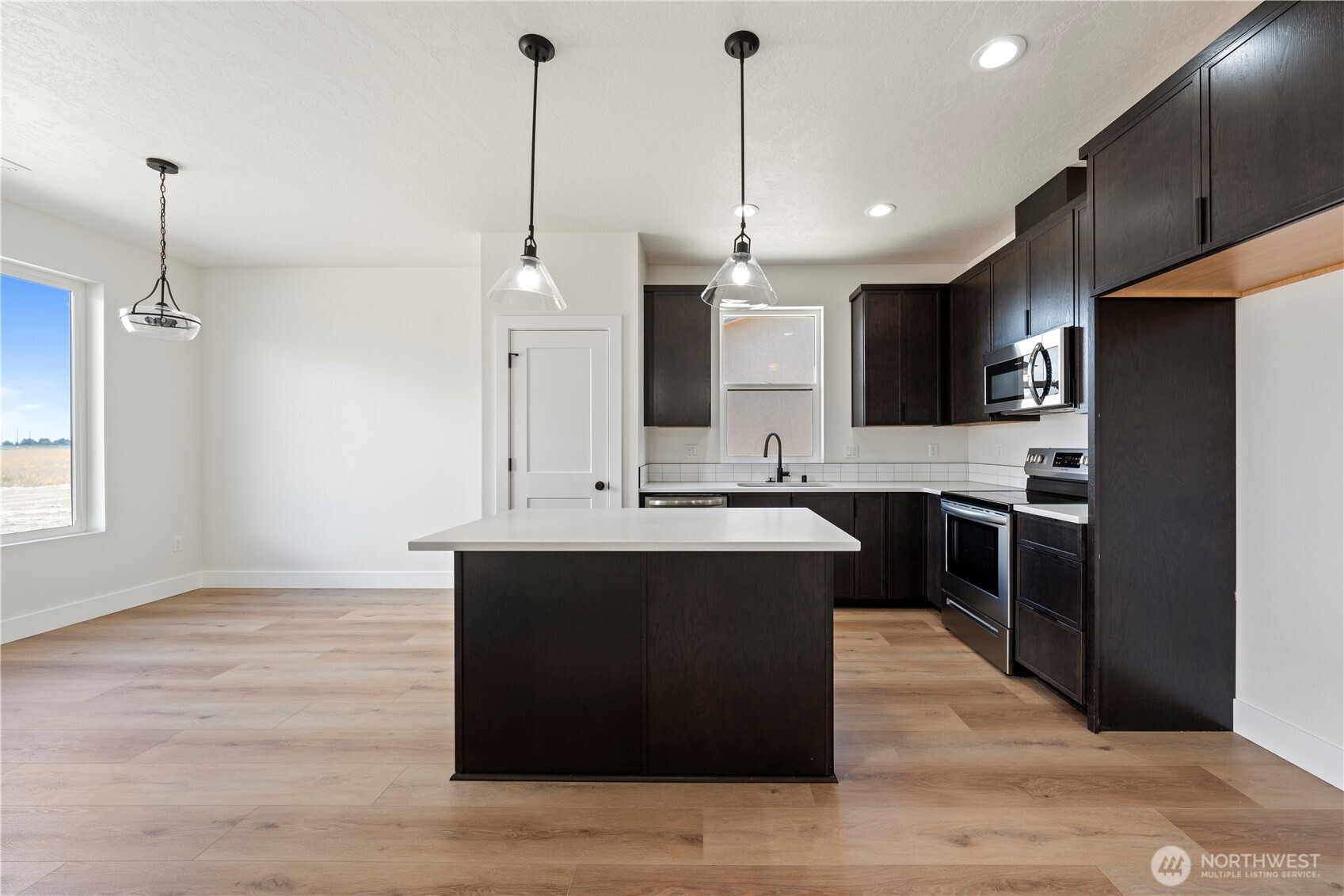 1111 E Mount Othello, WA 99344 - Photo 8 of 34 a kitchen with kitchen island sink and refrigerator