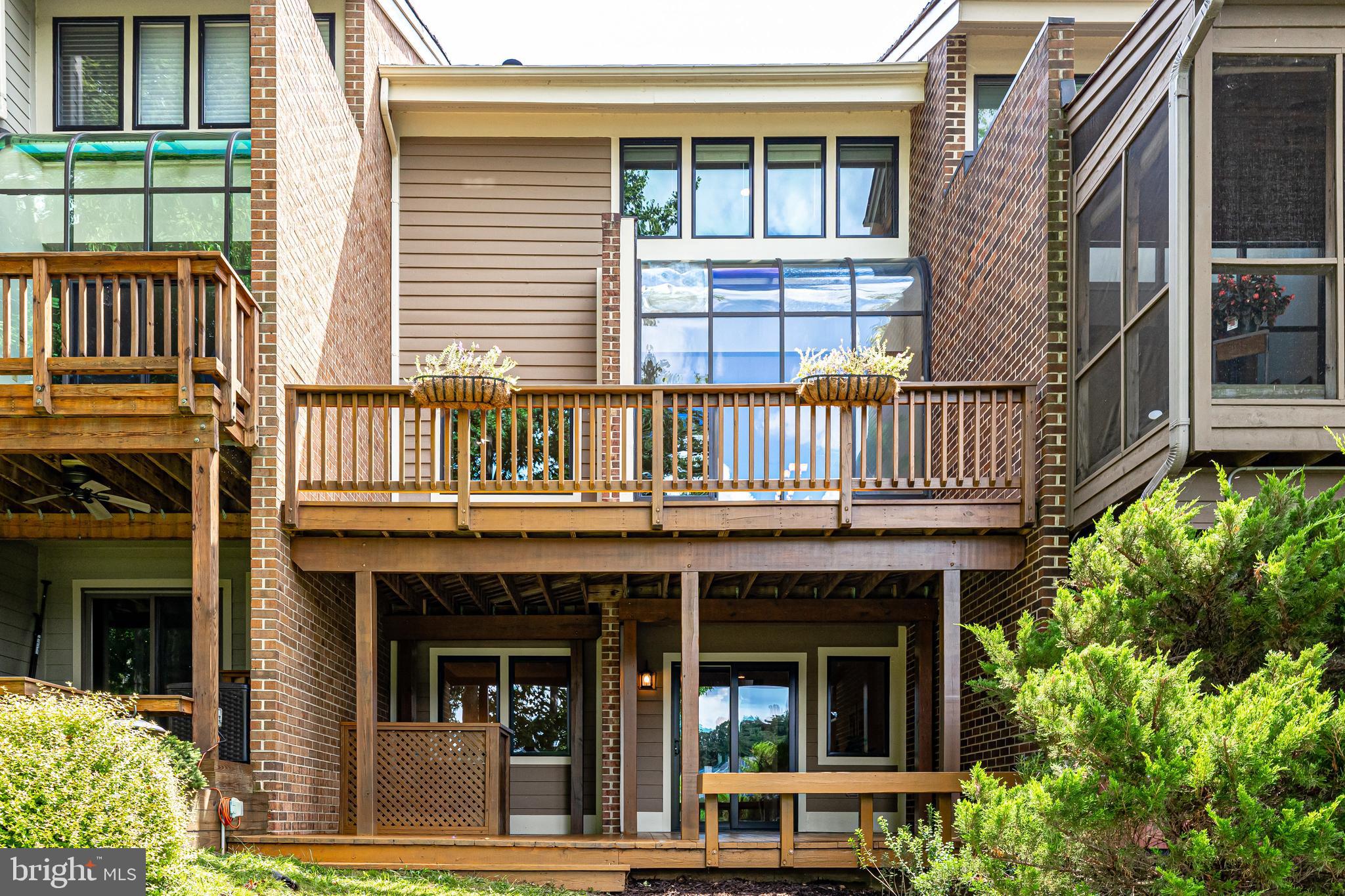 11056 Thrush Ridge Road Reston, VA 20191 - Photo 54 of 62 a view of a brick house with large windows and plants