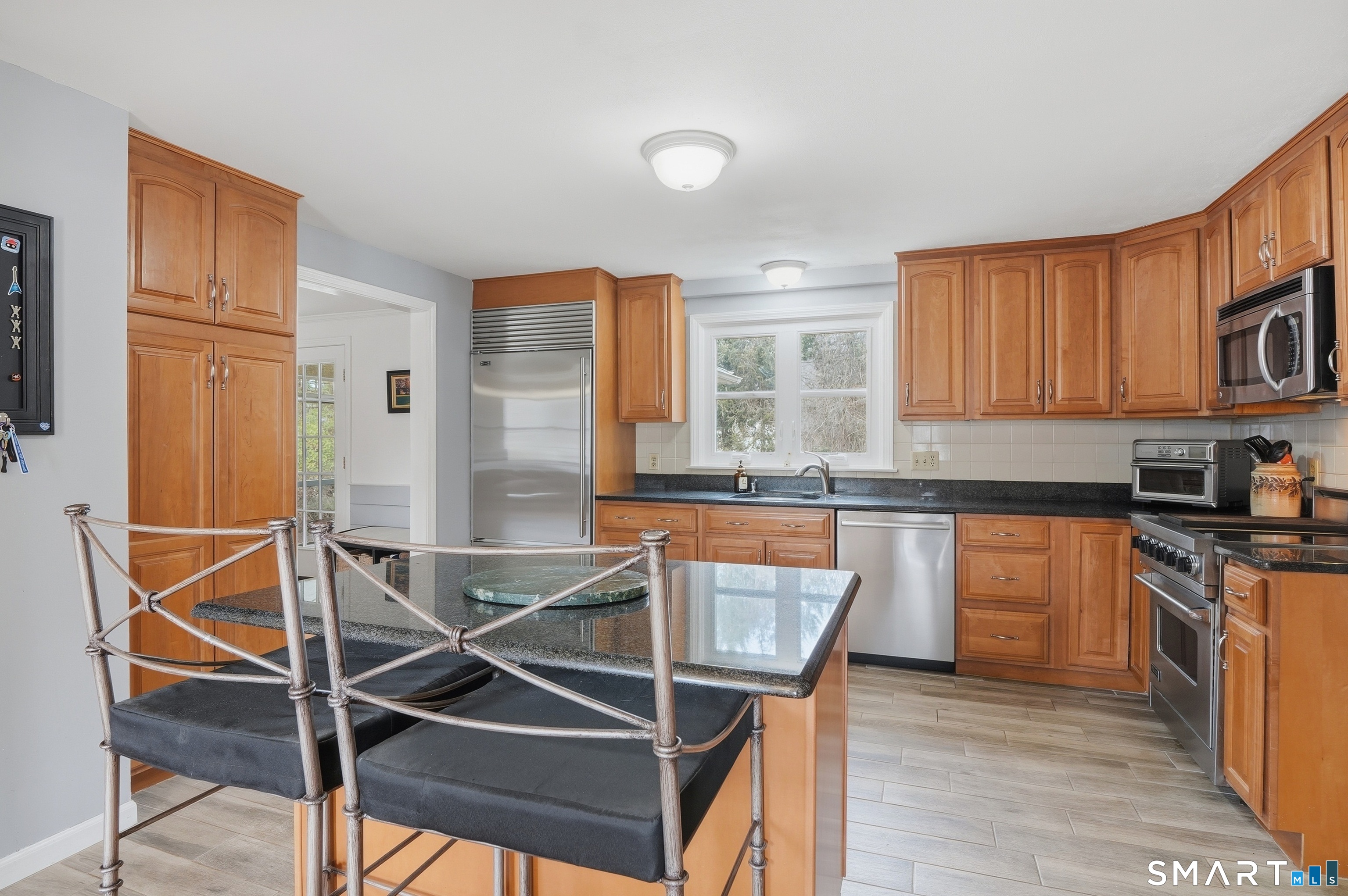 88 Nob Hill Road Cheshire, CT 06410 - Photo 13 of 40 a kitchen with kitchen island granite countertop wooden floors and white cabinets